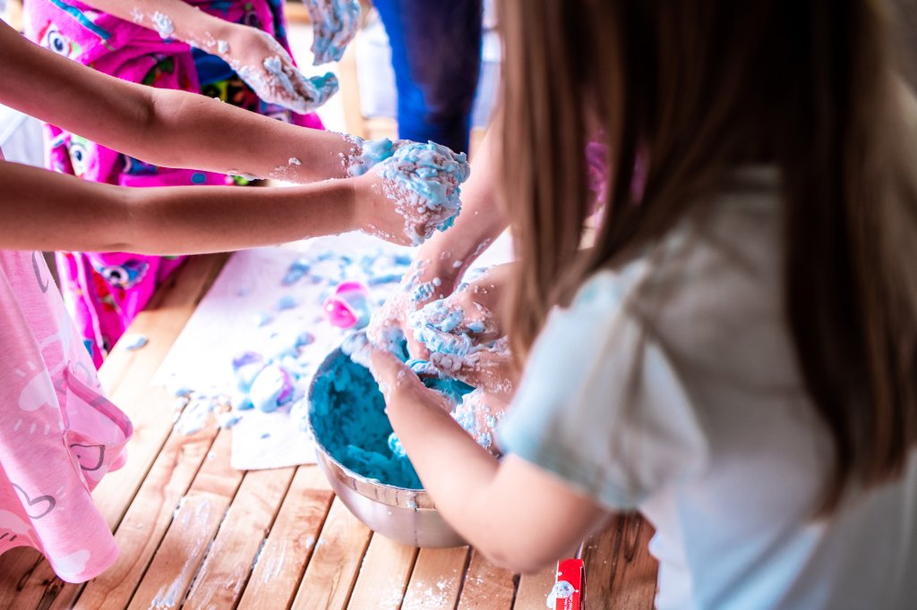 Children play with coloured foam at a party.